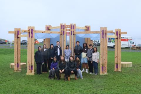 BuildFest participants standing in front of a wood-framed installation.